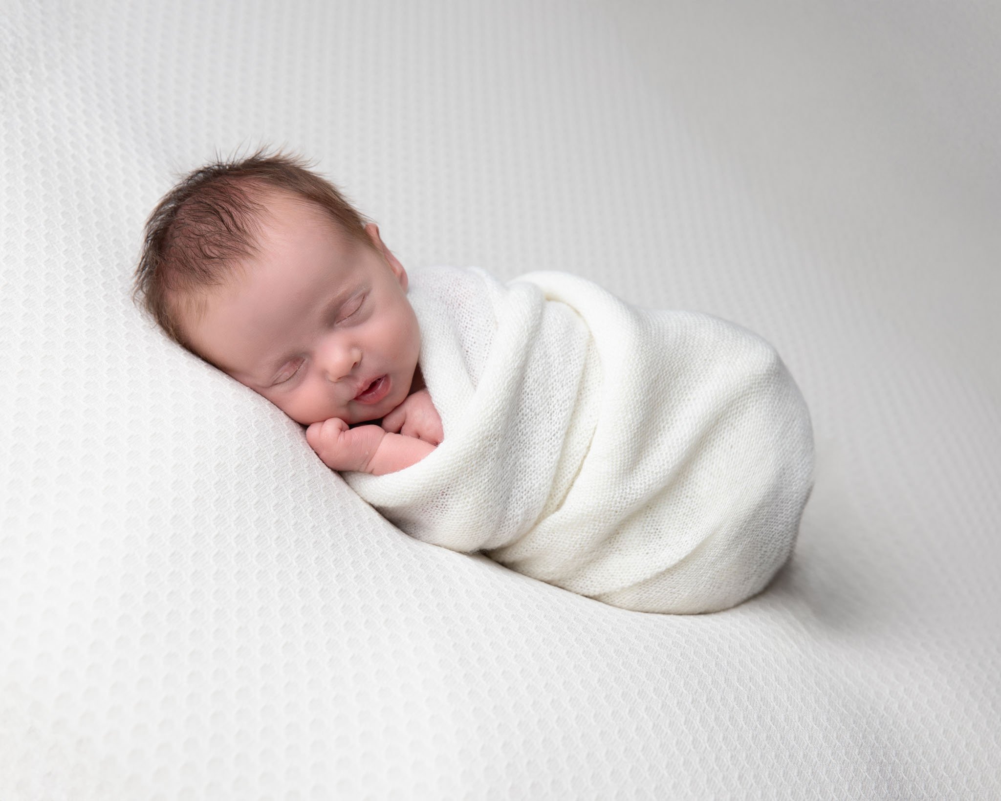newborn baby, swaddled in a white blanket, fast asleep and peacefull, by Newborn photographer in Somerset, Wiltshire and Bath